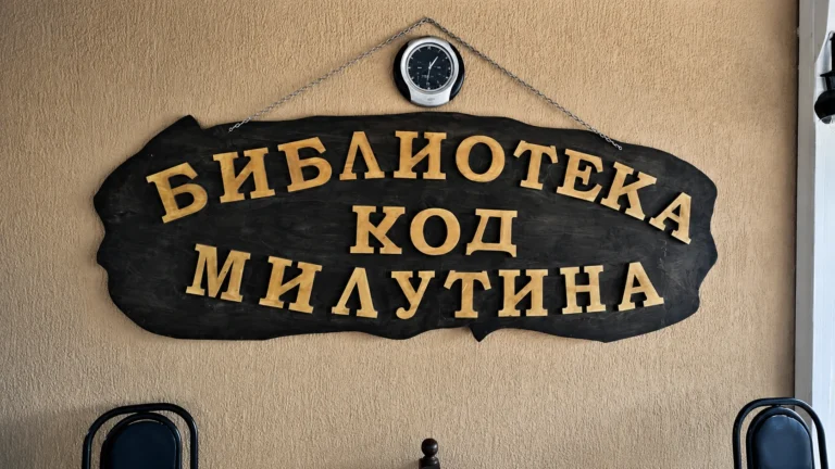 Drveni natpis Biblioteka kod Milutina sa ćiriličnim slovima na ulazu u restoran.
